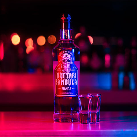 Two alcoholic shots of Nottari Bianca Sambuca with the Nottari bottle placed next to the shots. 