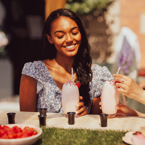 Two woman drinking alcoholic strawberry vegan milkshakes made with Lustre Strawberry Cream Tequila, a vegan cream liqueur. 