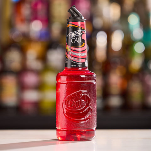 Finest Call Cosmopolitan on a bar counter with blurred bottles in the background