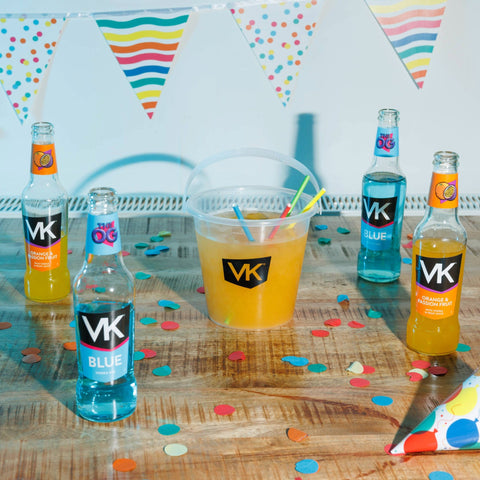 Displaying the Pres pack (OG Flavours) lifestyle with partly drunk bottles of VK Blue and VK Orange & Passionfruit next to a VK Cocktail Bucket